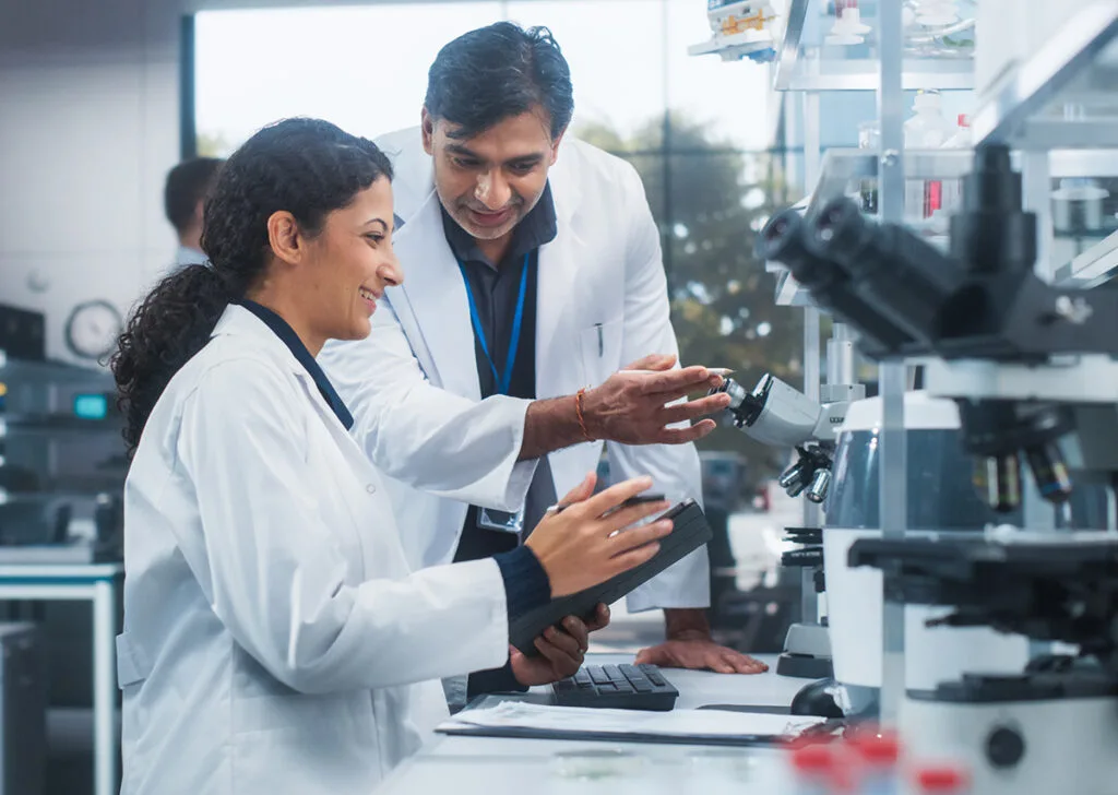 Scientists discussing research in laboratory setting.