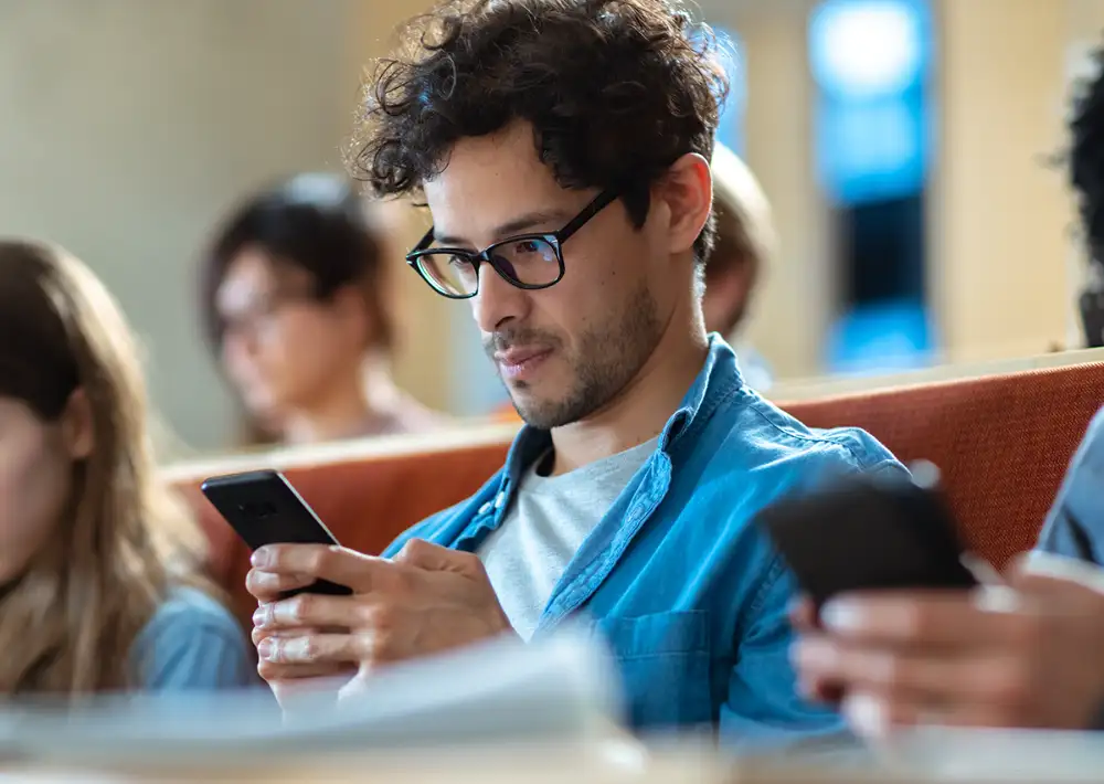 Person using smartphone in a lecture hall