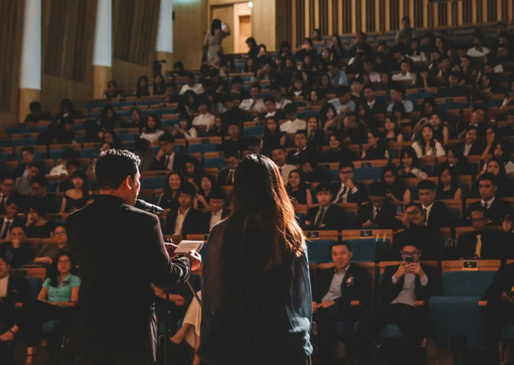 Speaker addressing a full auditorium audience