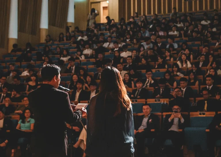 Speaker addressing a full auditorium audience